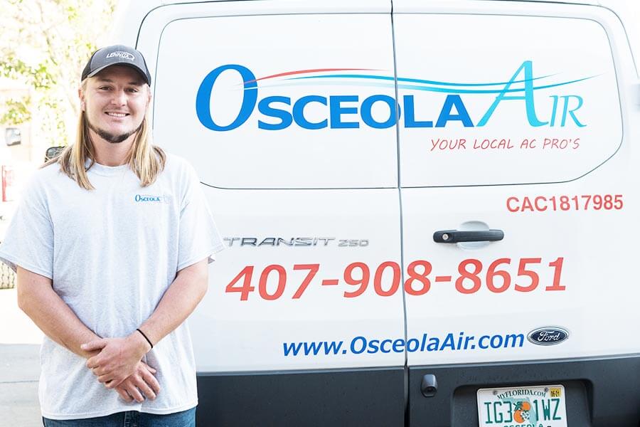 Air Conditioner Repair Tech In Front Of Van
