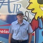 Meet Our Team: A man wearing glasses, a gray cap, and a light blue shirt stands in front of a colorful vehicle with cartoon graphics and large text that reads "Air.