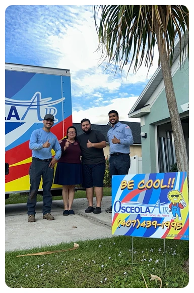 Four people stand in front of a house and an Osceola Air truck, next to a lawn sign with the company’s name and phone number, posing and smiling for the photo.