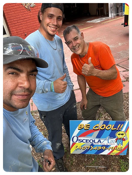 Three men smiling and giving thumbs up pose outdoors near a "Be Cool!! Osceola Air" service sign with a phone number.