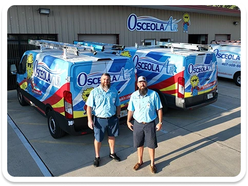 Two men in blue uniforms stand in front of Osceola Air service vans parked outside a building with an Osceola Air sign.