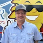 Meet Our Team: A man in a light blue Osceola Air uniform and cap stands in front of a colorful van with a sun graphic.