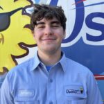 Meet Our Team: A young man in a work shirt labeled "Jeremy" stands smiling in front of a colorful Osceola company vehicle.
